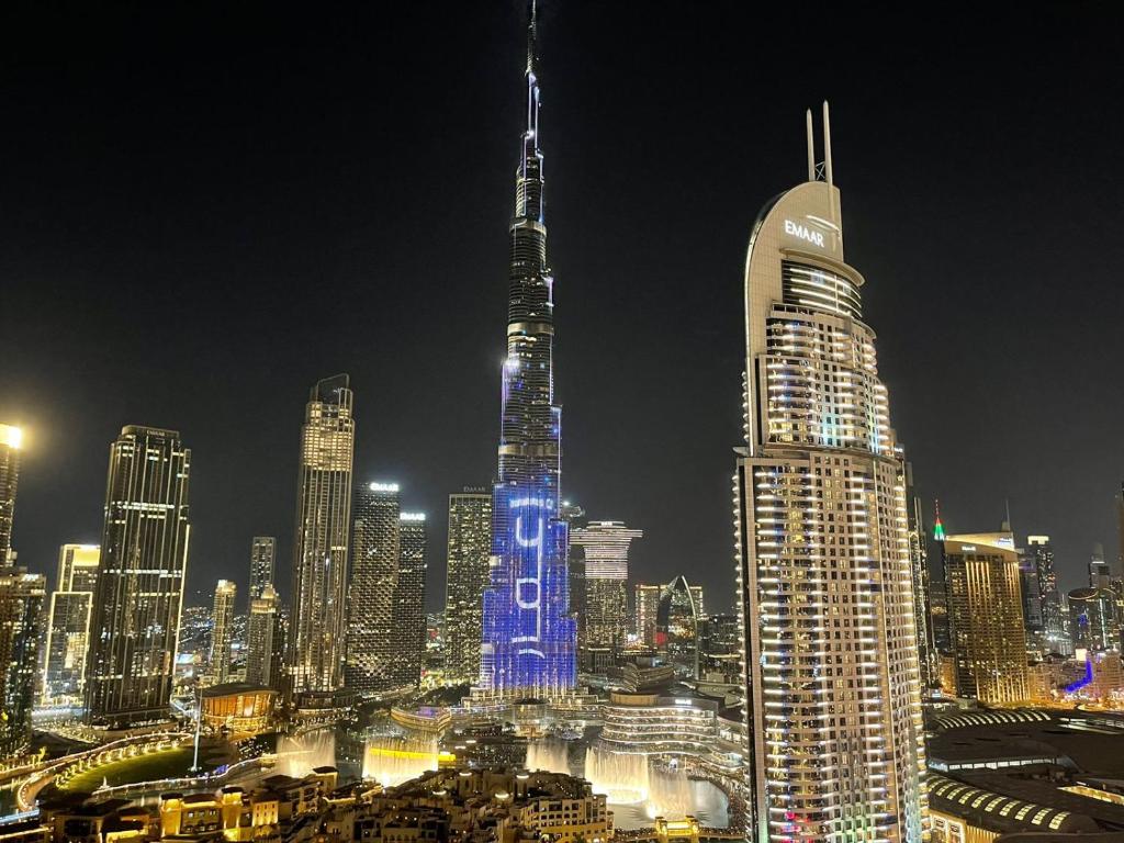 uma vista noturna de uma grande cidade à noite em Luxury 2BR High floor Apt. w/ Burj Khalifa view with laser light show and Dancing Fountain View em Dubai