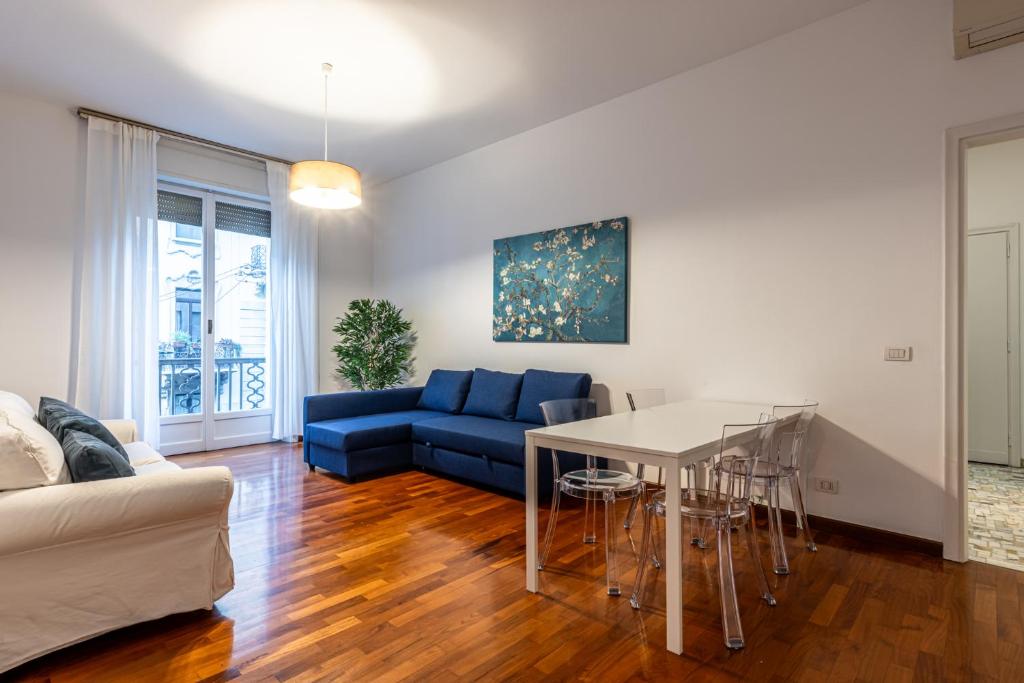 sala de estar con sofá azul y mesa en Cortivo House - Magenta 81, en Milán