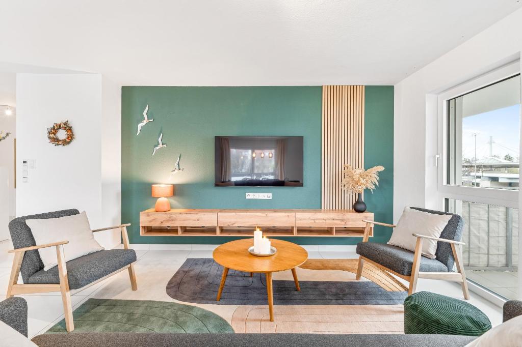 sala de estar con TV, 2 sillas y mesa en Design-Apartment - Küche - Parken - zentral, en Leinfelden-Echterdingen