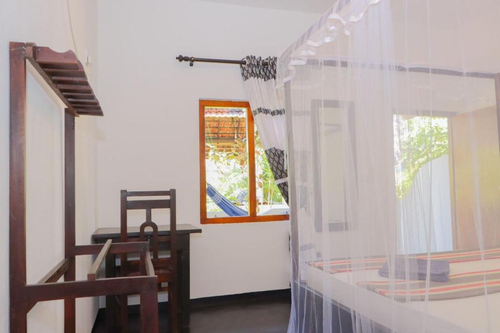 Habitación con ventana, mesa y silla en Lucky Bay, en Arugam Bay