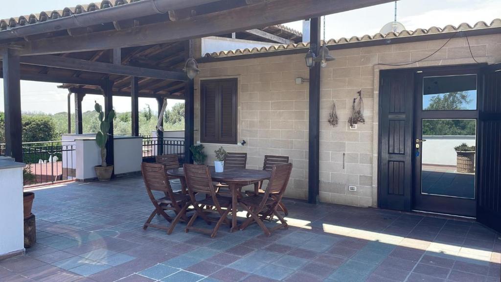 eine Terrasse mit einem Tisch und Stühlen auf einem Haus in der Unterkunft Agriturismo Villa Pina in Lizzanello