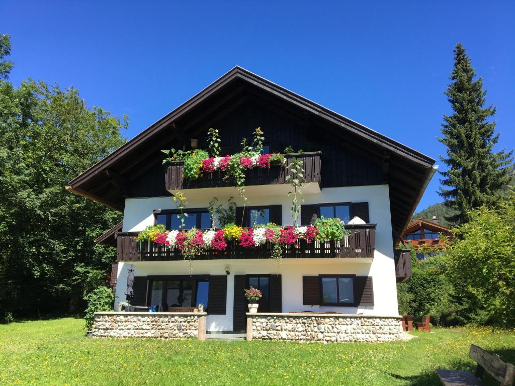 una casa con flores en los balcones en Ferienwohnung Klausgraben, en Bischofswiesen