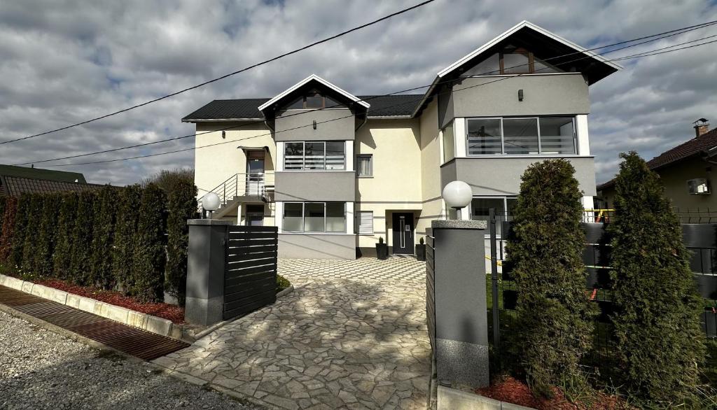 una gran casa blanca con una valla delante en Apartmani Lotus Vrdnik, en Vrdnik