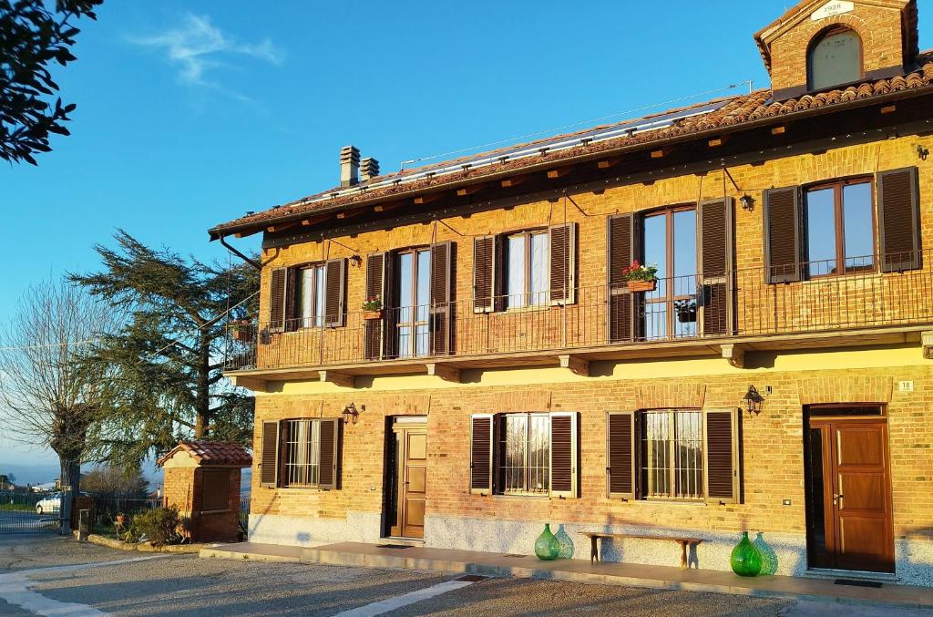 um edifício de tijolos com um banco à frente em Casa Rubbo - Appartamento in collina 'Monviso' em Alba