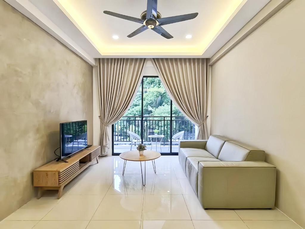 a living room with a couch and a ceiling fan at The Cove Hillside Residence Ipoh in Ipoh
