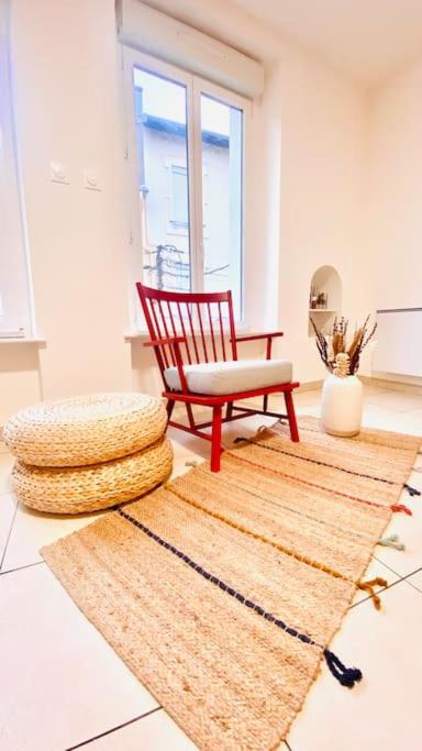 einen roten Stuhl und einen Teppich in einem Zimmer in der Unterkunft Appt Longwy, très bien situé in Longwy