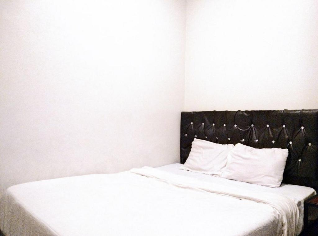 Postel nebo postele na pokoji v ubytování Gangnam Style Residence Mitra RedDoorz near MERR Surabaya