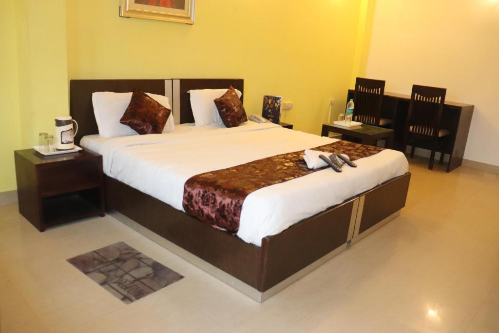 a large bed in a room with two chairs at HOTEL DV PLAZA INN in New Delhi