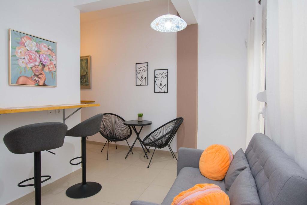 sala de estar con sofá, mesa y sillas en Handakos Loft "by Checkin" en Heraclión