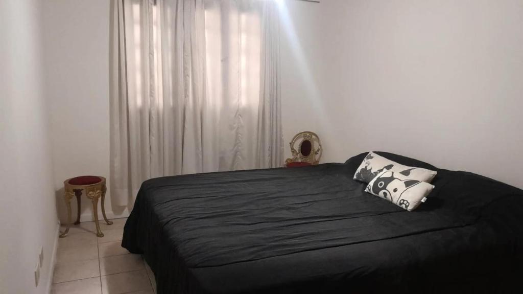 a bedroom with a black bed and a window at Departamentos Parque Benegas in Godoy Cruz