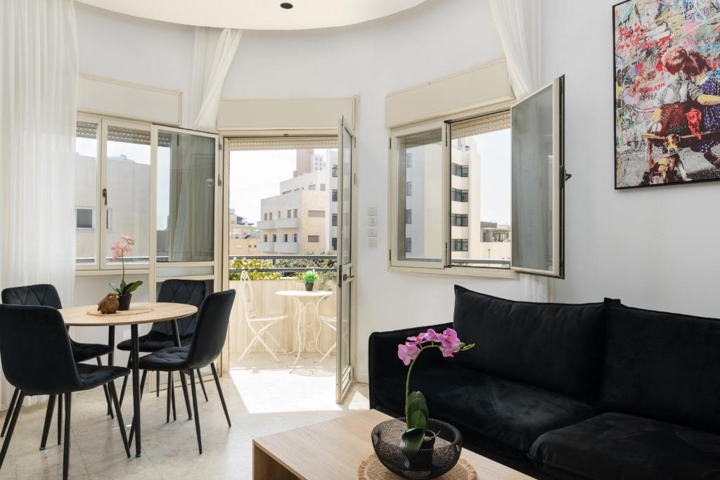 sala de estar con sofá negro y mesa en Bauhaus 2BR with Sea View & Balcony by FeelHome, en Tel Aviv