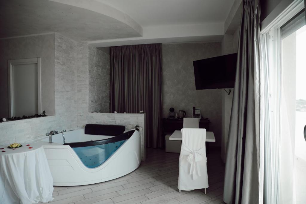 a bathroom with a tub and a television in it at BlueBay Residence Resort in Taranto