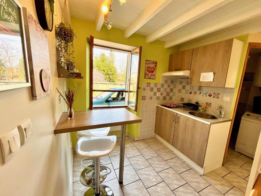 una pequeña cocina con mesa y fregadero en Le Clocher de Leonie by LPNL en Renage