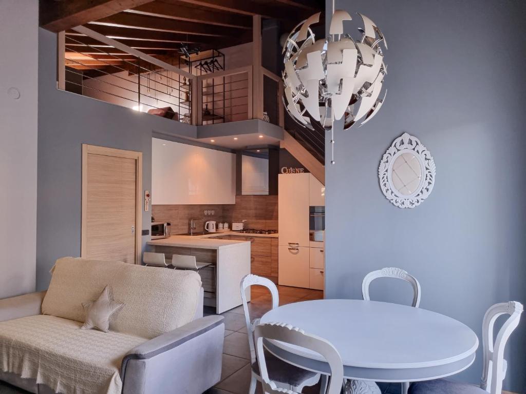 a kitchen and dining room with a white table and chairs at Loft Civico 12 in Pian Camuno
