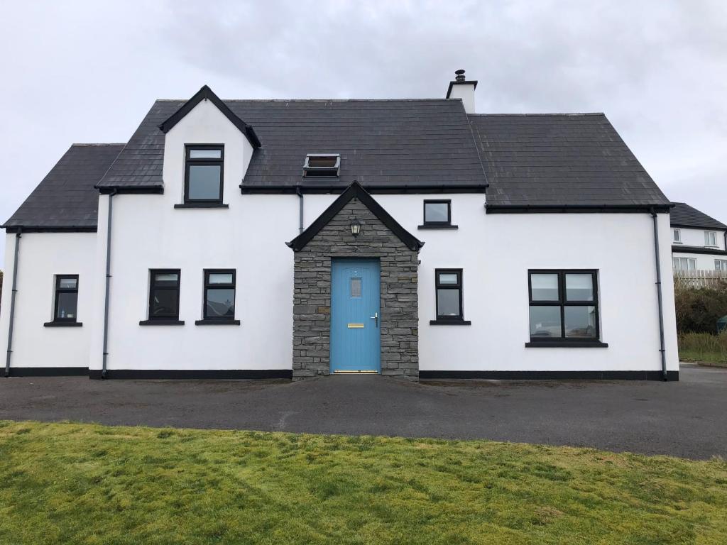 una casa blanca con una puerta azul en An Teach Bán, en Falcarragh