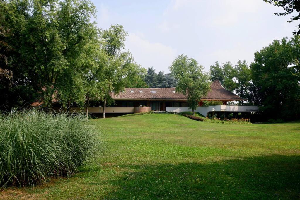 een huis met een grasveld ervoor bij [LUXURY]・VILLA ☆☆☆☆☆・Pool, Sauna and Park in Sedriano