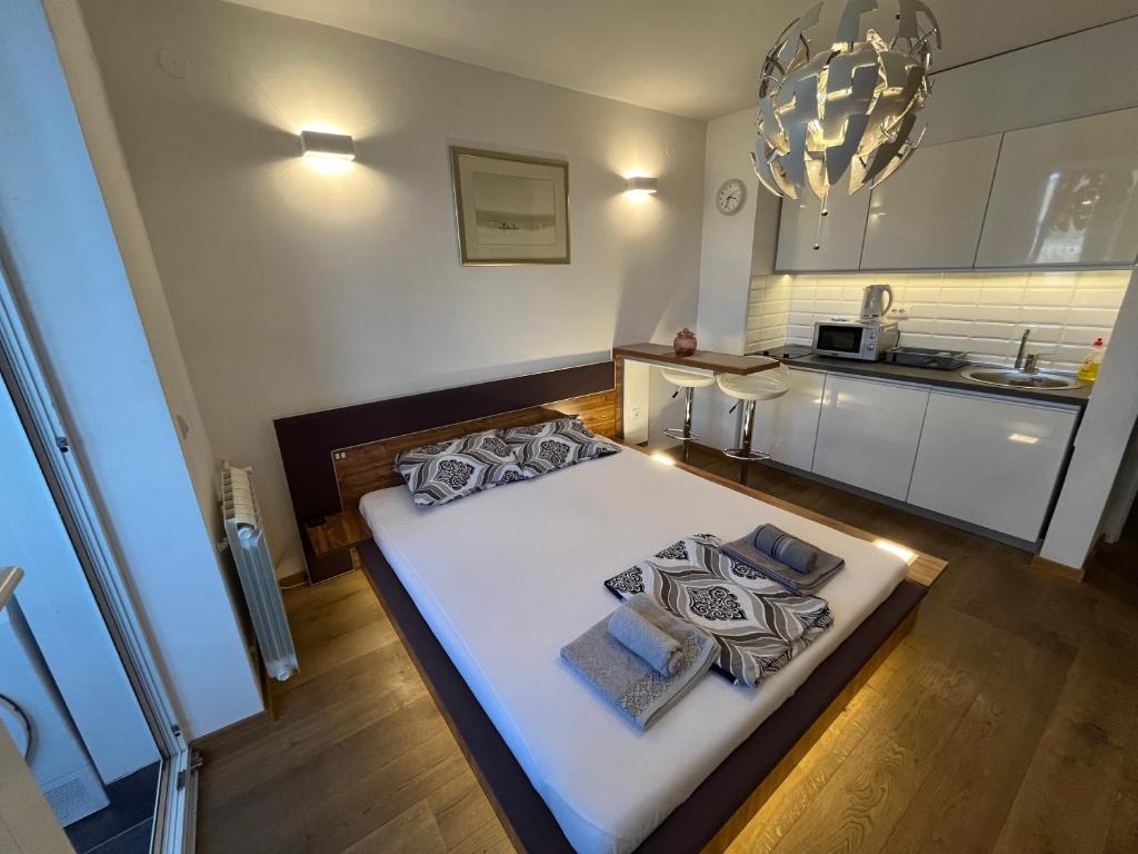 uma cama grande num quarto com uma cozinha em Hedonic Studio em Belgrado