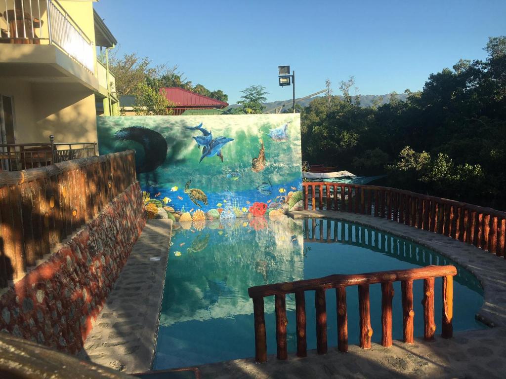 a swimming pool with a painting on the side of a building at Seashore Garden Resort in Moalboal