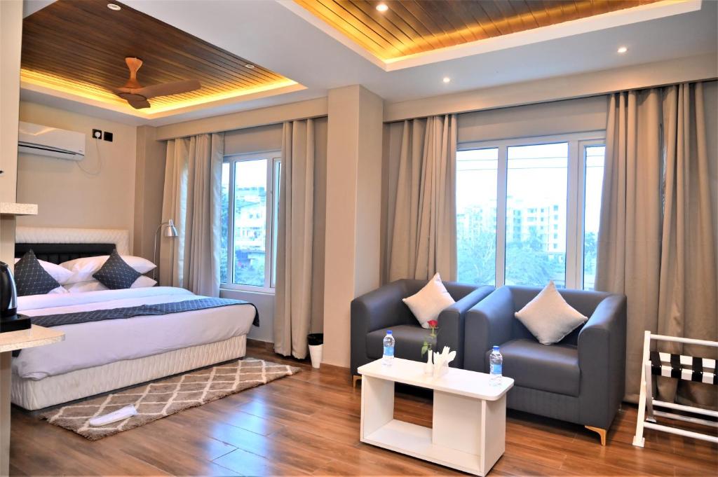 una habitación de hotel con una cama y un sofá en ESSENCE GRANDEUR, en Guwahati