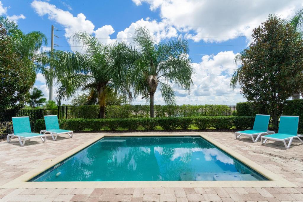 una piscina con sillas y una palmera en Top Villas - Encore Resort 1528, en Orlando