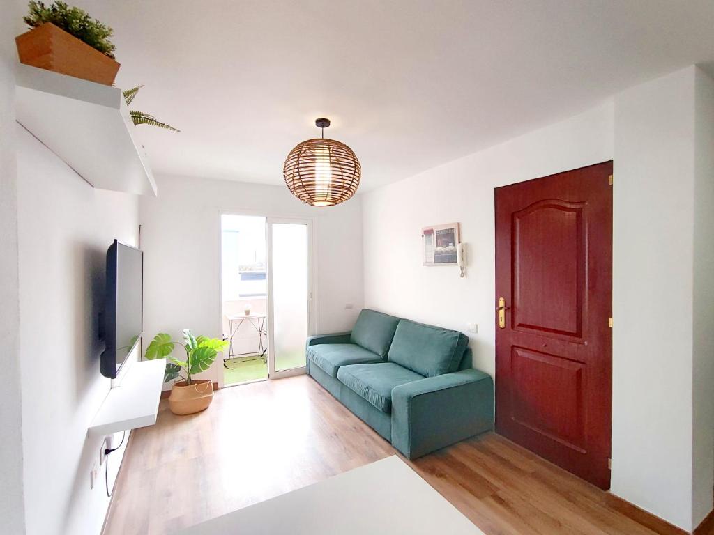ein Wohnzimmer mit einem blauen Sofa und einer roten Tür in der Unterkunft Pozo Wave Properties in Pozo Izquierdo