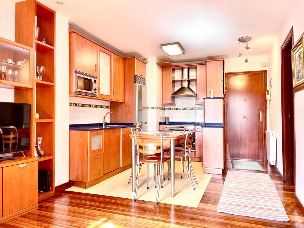 a kitchen with wooden cabinets and a table and chairs at Mundaka bihotzean con parking gratuito in Mundaka