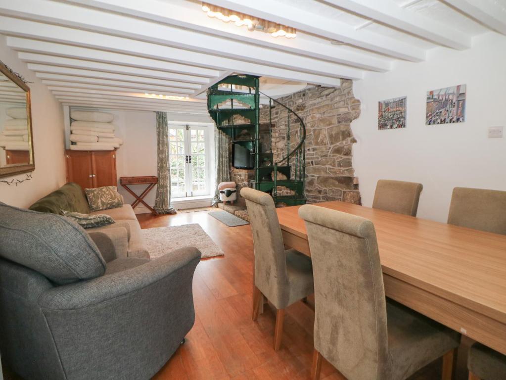 a dining room with a wooden table and chairs at Bear Pit Cottage in Hayfield