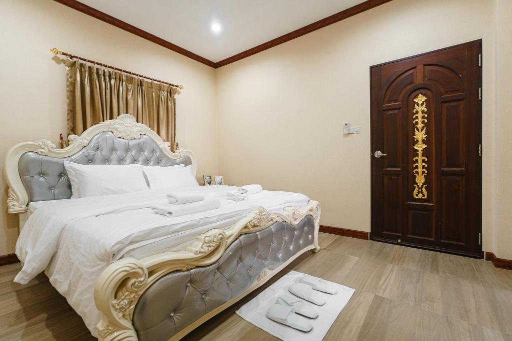 1 dormitorio con 1 cama grande y puerta de madera en The Crystal Ranong, en Ban Lum Than
