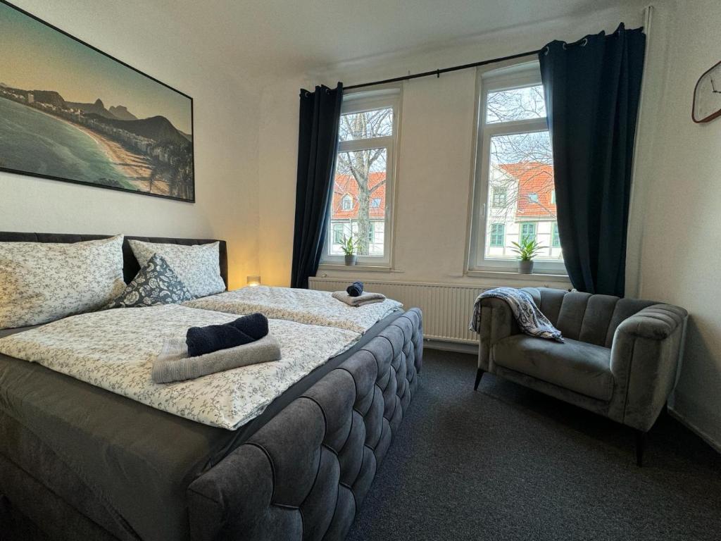 sypialnia z łóżkiem, krzesłem i oknami w obiekcie Apartment Goethe in der Göttinger Innenstadt w Getyndze