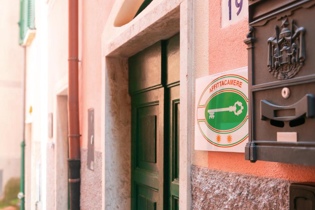 a sign on the side of a building with a green door at DEMIVIE GUESTHOUSE in Lerici