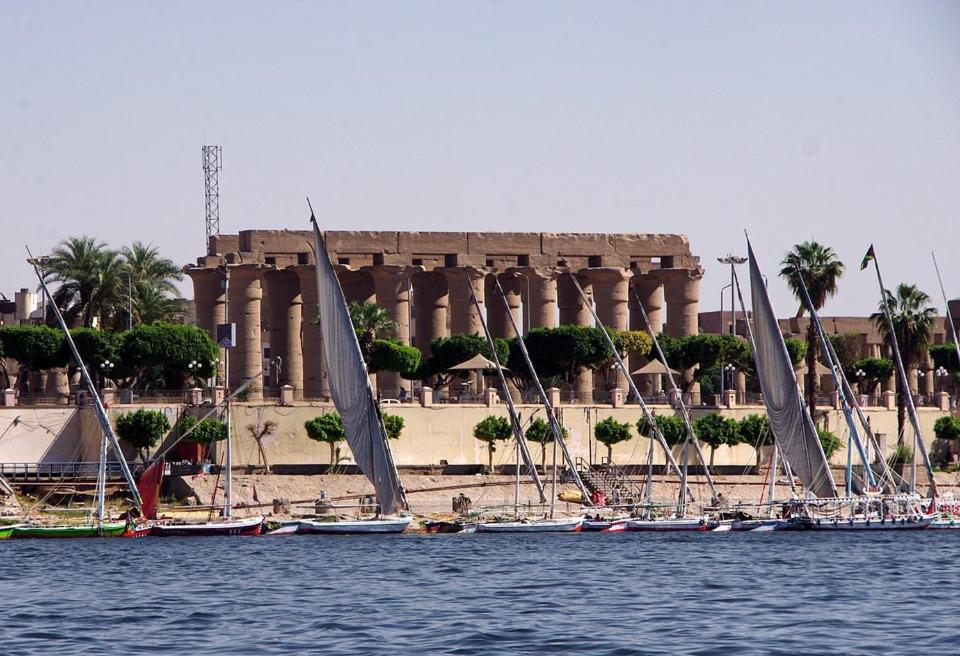 a group of sailboats on the water in front of a building at luxo bankr west in Luxor