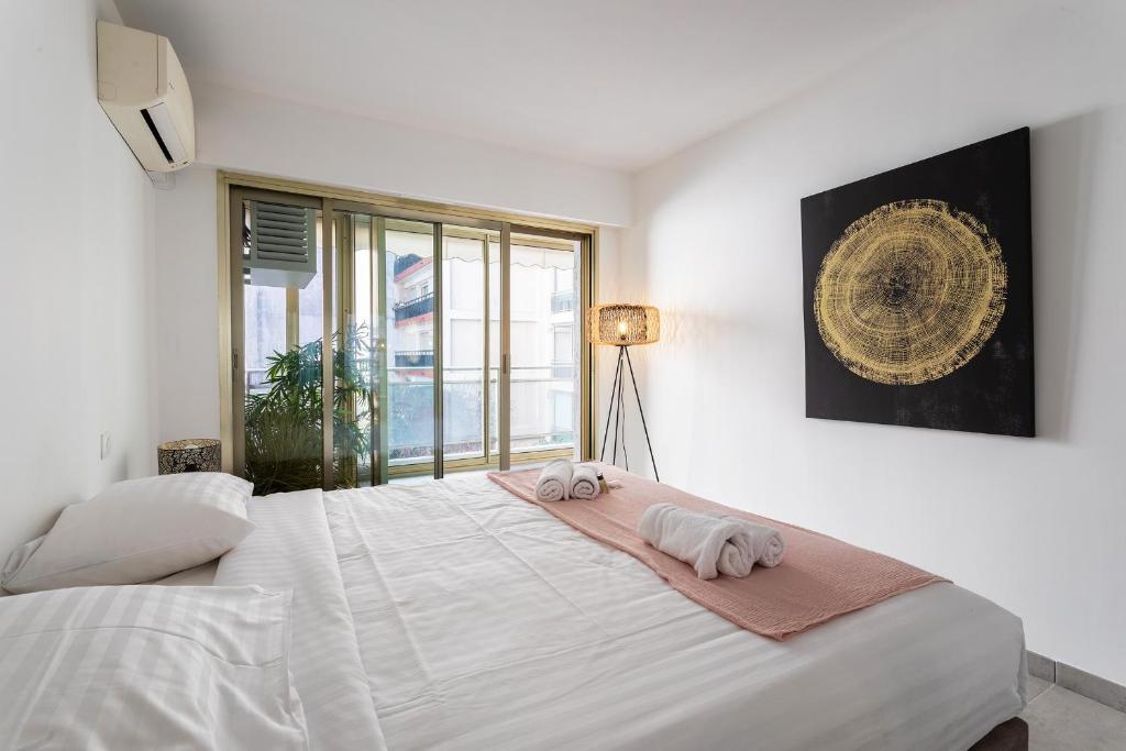 une chambre avec un grand lit blanc avec des serviettes dessus dans l'établissement OMAN1 Magnifique et modern deux pieces, à Cannes