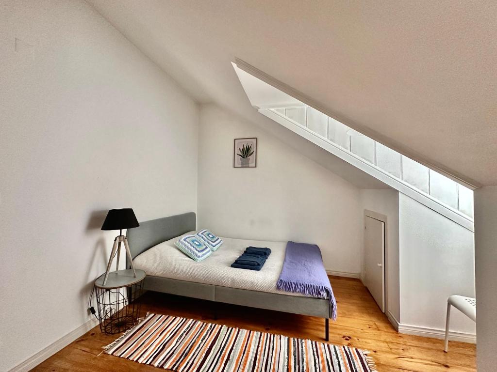 um quarto com uma cama num quarto branco em Alcantara 2 Bedrooms Apartment em Lisboa