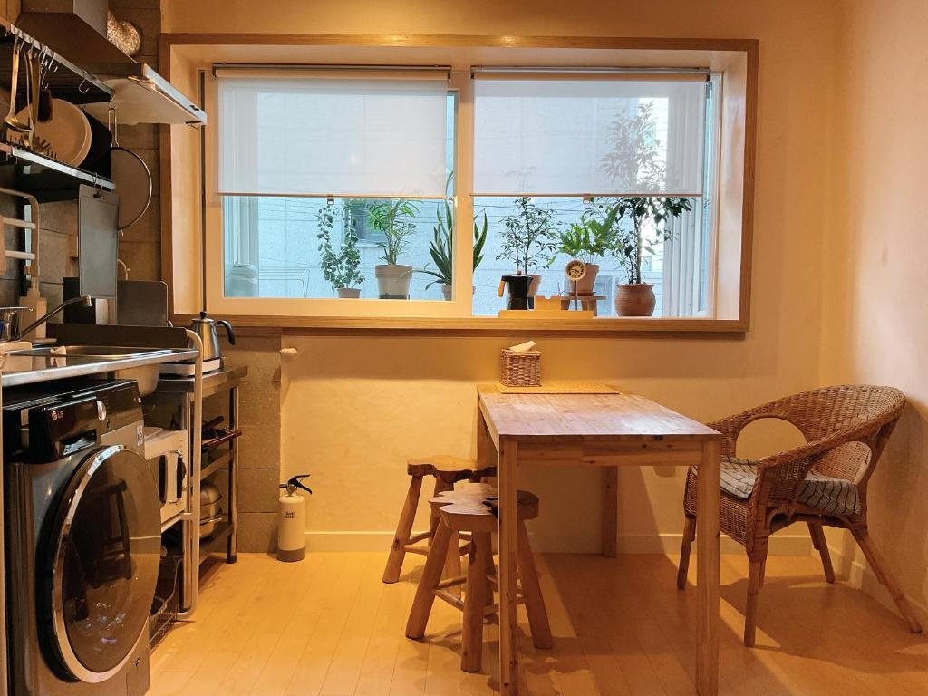 eine Küche mit einem Tisch und einem Fenster mit Topfpflanzen in der Unterkunft liilliil Residence Seoul in Seoul