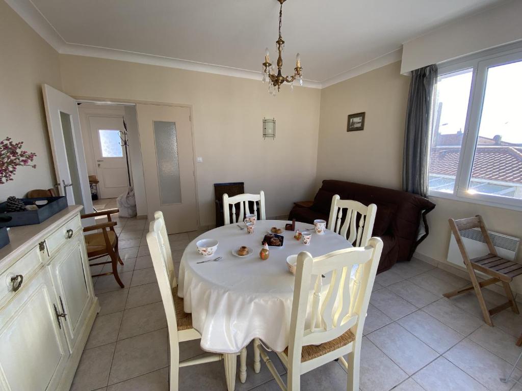 une table à manger et des chaises dans un salon dans l'établissement LS05022 Le Petit Ampère 700m de la plage, à Les Sables-dʼOlonne