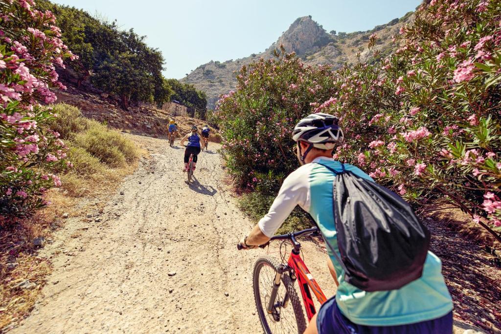 two people riding bikes on a dirt road at TUI Magic Life Candia Maris - Adults Only in Amoudara Herakliou