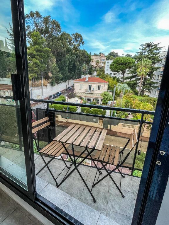 d'un balcon avec un banc en bois et une table. dans l'établissement Cocon Riviera, à Cannes