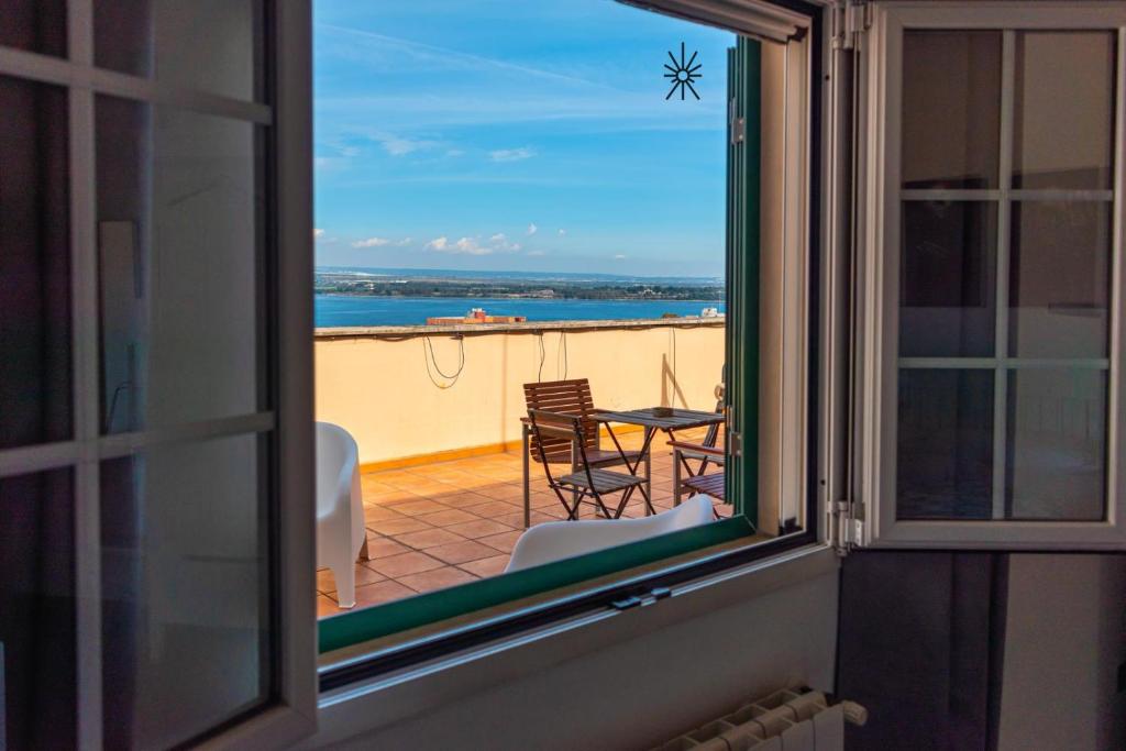 a window view of a patio with a table and chairs at Rooftop Madreperla in Taranto