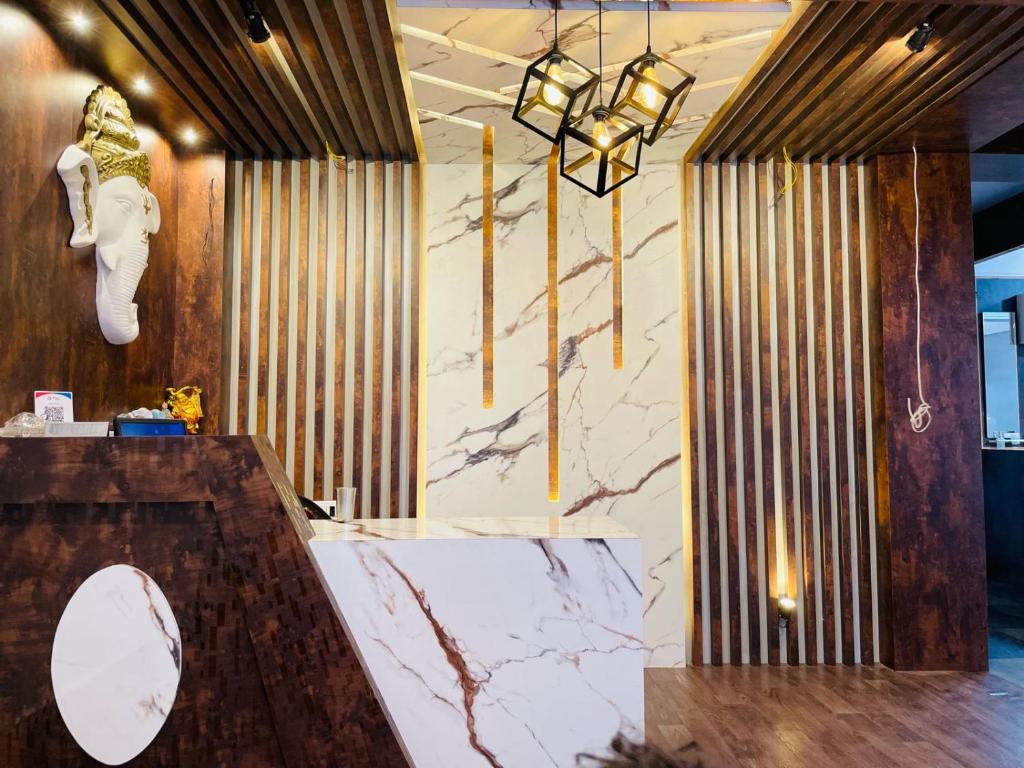 a lobby with a marble counter and lights on the wall at Anjali Delux in Kalimpong