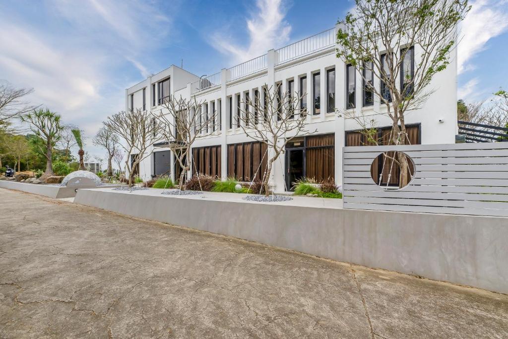 a white building with trees in front of it at Moda & the Moon B&B in Miaoli