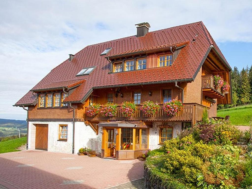 ein großes Haus mit einem Balkon mit Blumen darauf in der Unterkunft Ferienhaus Esche in Hinterzarten