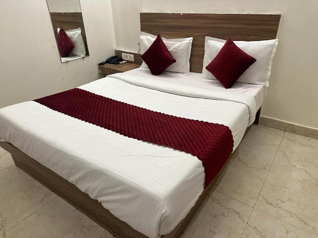 a bedroom with a large bed with red pillows at Mint Hotel in New Delhi