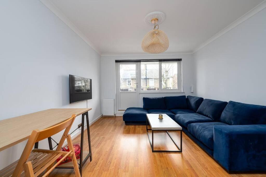 a living room with a blue couch and a table at GuestReady - Cosy nest with balcony in London in London
