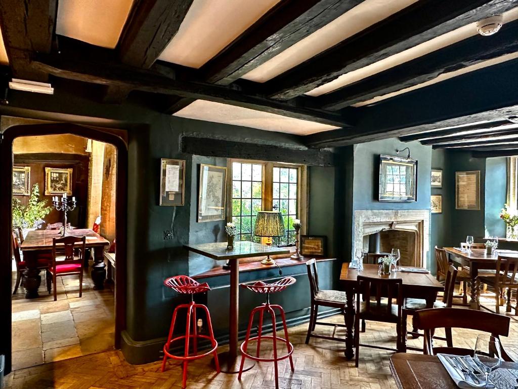 a dining room with tables and chairs and a fireplace at The Crown at Shipton in Shipton under Wychwood