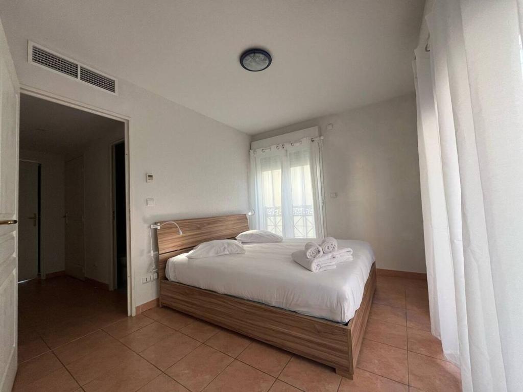 1 dormitorio con 1 cama y reloj en la pared en Villa Azzurra superbe 2P centrale et vu mer en Menton
