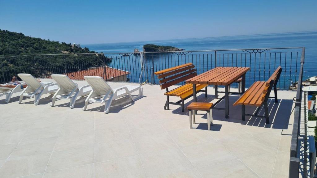 un patio con tavolo, sedie e vista sull'oceano di Apartments Relax a Utjeha