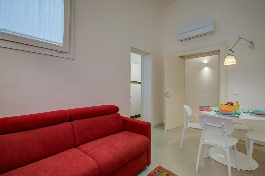 sala de estar con sofá rojo y mesa en Casa Rossa Near Lecce Centre - Happy Rentals, en Lecce