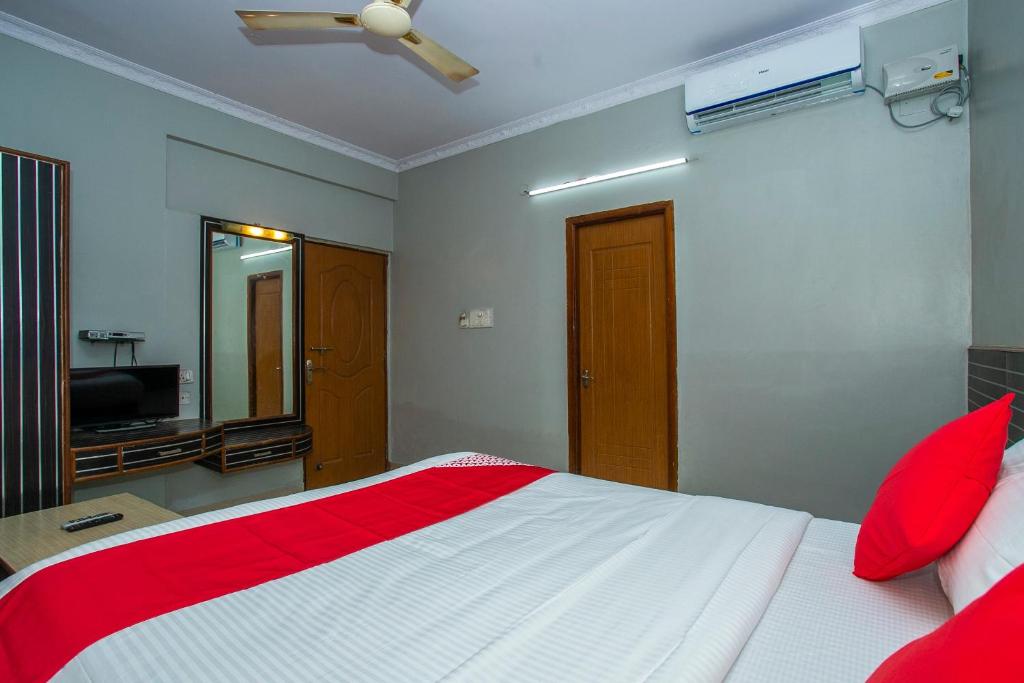 a bedroom with a red and white bed and a television at Flagship White Fort Near Lalbagh Botanical Garden in Bangalore