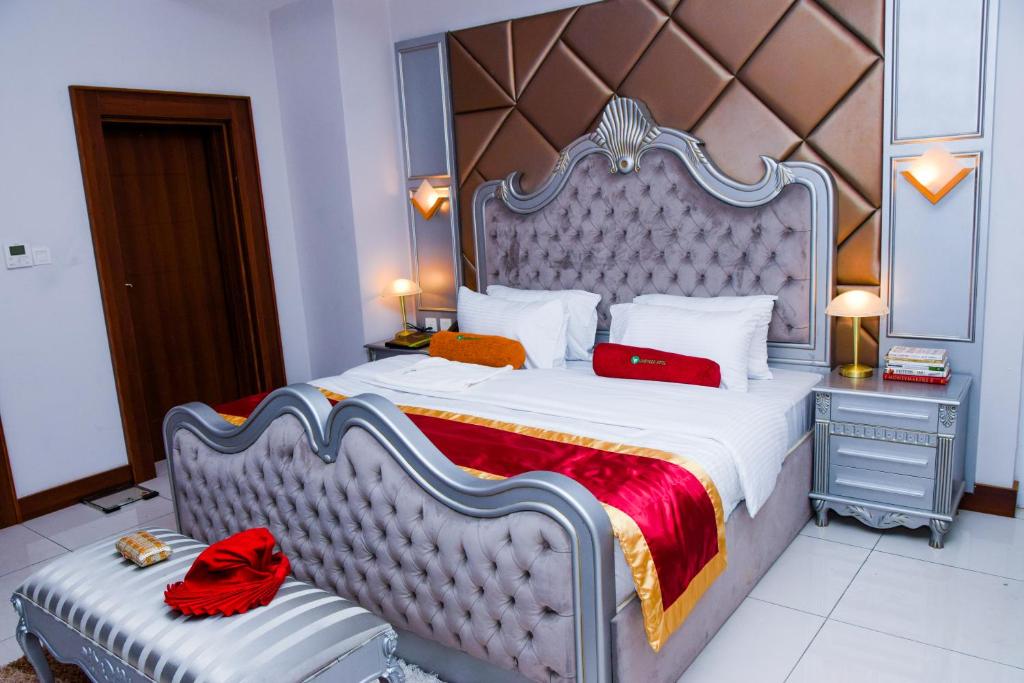 a bedroom with a large bed with a large headboard at LIMEWOOD HOTEL in Port Harcourt