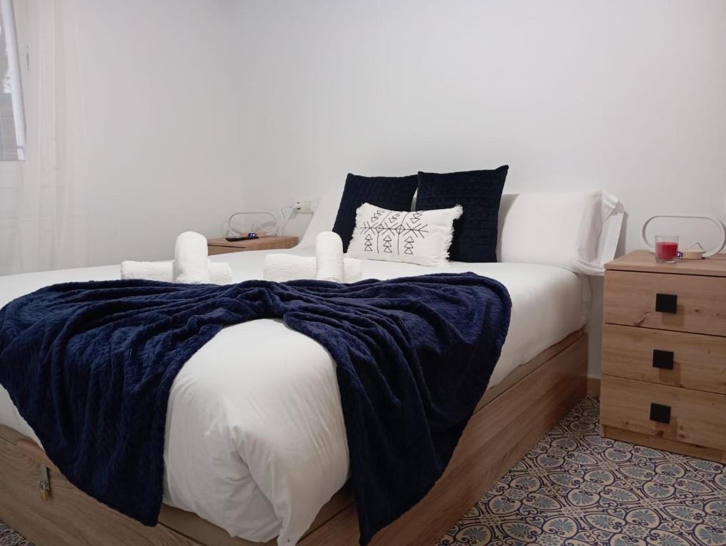 - une chambre avec un lit et une couverture bleue dans l'établissement Gardenia Apartment, à Séville